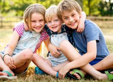 Three young siblings sitting together