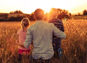 Father and children looking at sunset
