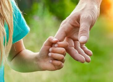 Little girl holding adult hand