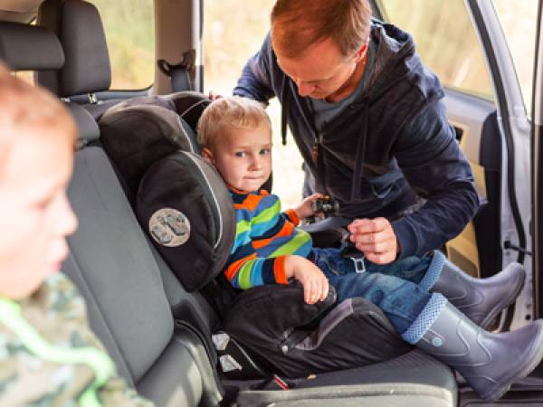 Dad putting child in car seat
