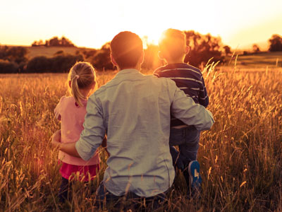Father and children looking at sunset