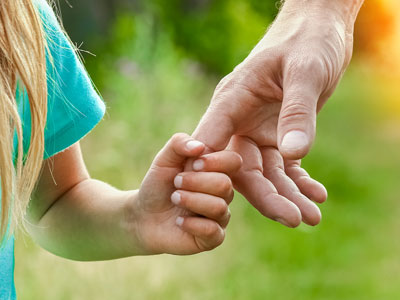 Little girl holding adult hand